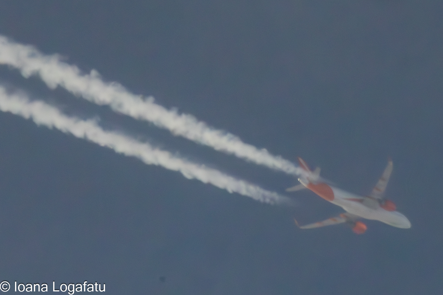 Clouds surround a jet leaving trails in the sky